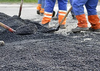 Group of people working on spreading asphalt
